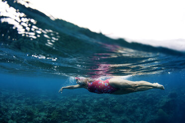 Unterwasseransicht eines Schwimmers, der ein entspannendes Bad in den tropischen Gewässern vor der Insel Mana, Fidschi, genießt. - AURF01591