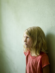Ein Mädchen lehnt an der Wand und blickt zur Decke - AURF01609