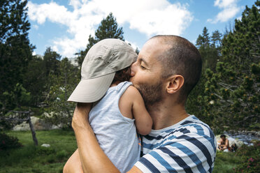 Spanien, Vater umarmt und küsst seine kleine Tochter in der Natur - GEMF02342