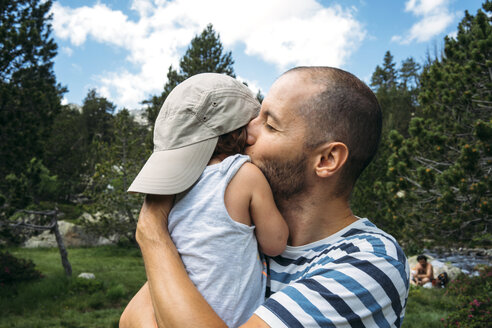 Spanien, Vater umarmt und küsst seine kleine Tochter in der Natur - GEMF02342