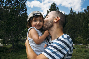 Spain, Father hugging and kissing his little daughter in nature - GEMF02343