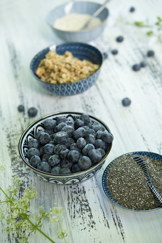 Bowls of blueberries, black chia seeds, granola and amaranth stock photo