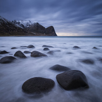 Wellen fließen zwischen Felsbrocken am malerischen Strand von Unstad, Vestv├Ñg├©y, Lofoten, Norwegen - AURF01684