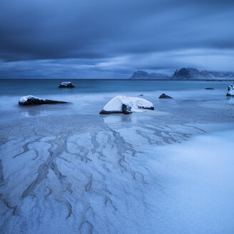 Wellen spülen im Winter über schneebedeckten Sand am Strand von Myrland, Flakstad├©y, Lofoten-Inseln, Norwegen - AURF01686