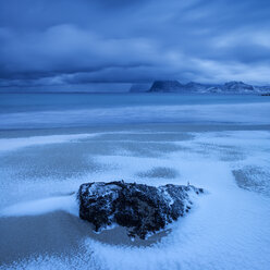 Wellen spülen im Winter über schneebedeckten Sand am Strand von Storsandnes, Flakstad├©y, Lofoten, Norwegen - AURF01689