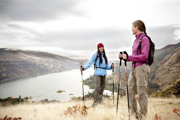 Two females taking a break while hiking with the Columbia Gorge in the background. - AURF01747