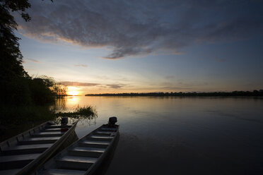 Zwei Boote sitzen bei Sonnenuntergang am Ufer des Amazonas in Peru. - AURF01750