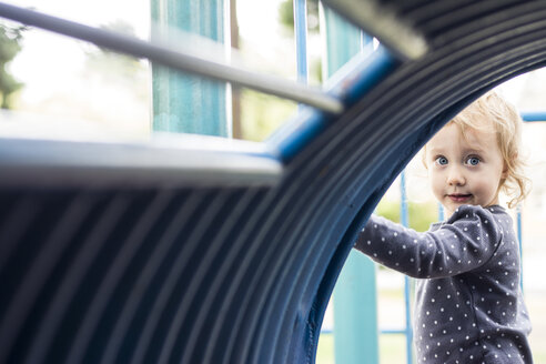 Kleines Mädchen schaut durch einen blauen Tunnel auf einem Spielplatz in Portland, Oregon. - AURF01767