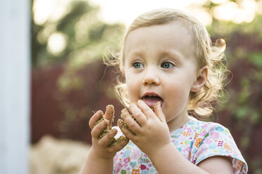 Toddler girl tastes sand from hands, Chico, California. - AURF01768