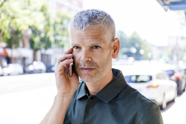 Portrait of mature man on cell phone in the city - TCF05695