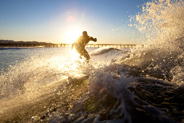 Ein Surfer reitet auf einer Welle am Port Hueneme Beach in der Stadt Port Hueneme, Kalifornien, am 22. Dezember 2007. - AURF01824