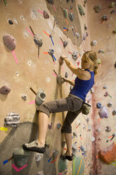 A woman rock climbing indoors at Estes Park, Colorado. - AURF01856