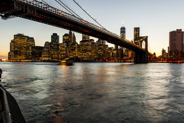 Die Brooklyn Bridge, der East River und der Finanzdistrikt mit dem neuen World Trade Center-Gebäude, New York City bei Sonnenuntergang. - AURF01861