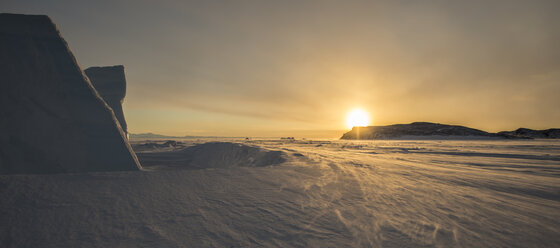 Sonnenuntergang hinter einem Eisberg mit Blick nach Norden über die gefrorene Oberfläche des Rossmeeres, Antarktis. - AURF01908