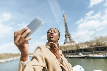 Frankreich, Paris, Frau macht ein Selfie mit dem Eiffelturm im Hintergrund - KIJF02012