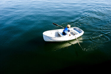 Ein Junge rudert ein Boot vor einer Insel in Maine - AURF01911