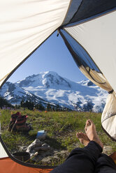 Ein Camper entspannt sich im Camp hoch auf dem Skyline Divide mit Blick auf den majestätischen Mt. Baker in der Mt. Baker Wilderness, Washington State. - AURF01917