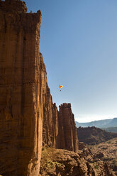 Ein Basejumper springt von einer Klippe in den Fisher-Türmen bei Moab, Utah. - AURF01924
