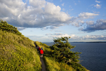 A family hikes along a trail while enjoying the views off the coast of Whidbey Island from Ebey State Park. - AURF01940