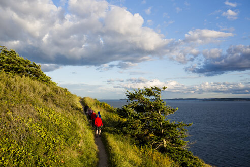 Eine Familie wandert auf einem Pfad und genießt dabei die Aussicht auf die Küste von Whidbey Island im Ebey State Park. - AURF01940