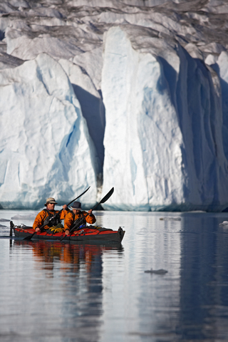 2 Mann in einem Doppel-Seekajak vor einem Gletscher, lizenzfreies Stockfoto
