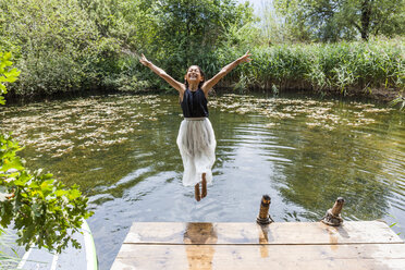 Unbekümmertes Mädchen springt in den Teich - TCF05746