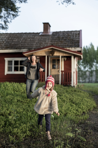 Finnland, Kuopio, Mutter mit Tochter läuft in einer Hütte auf dem Lande, lizenzfreies Stockfoto