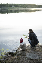 Finland, Kuopio, mother and daughter crouching at a lake - PSIF00037
