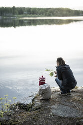 Finnland, Kuopio, Mutter und Tochter hocken an einem See - PSIF00037