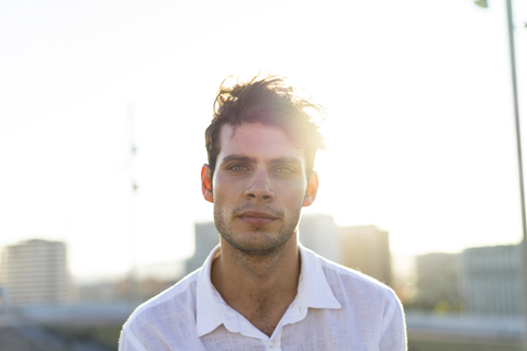 Portrait of handsome young man outdoors at sunset stock photo