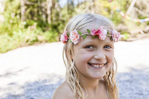 Portrait of happy girl wearing flower crown outdoors in summer stock photo