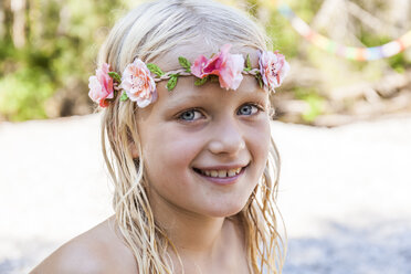 Porträt eines lächelnden Mädchens mit Blumenkrone im Freien im Sommer - TCF05755