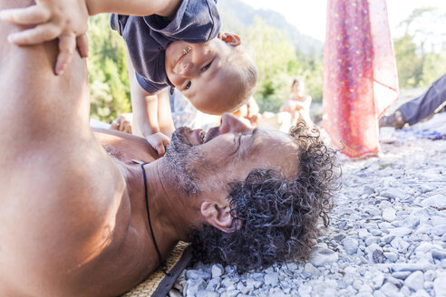 Glücklicher Vater, der seinen kleinen Jungen im Sommer im Freien hochhebt - TCF05759