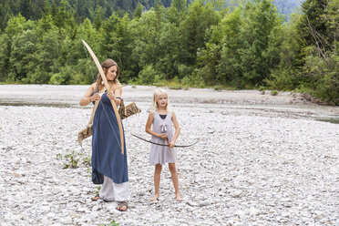 Mutter und Tochter mit Pfeil und Bogen in der Natur - TCF05788