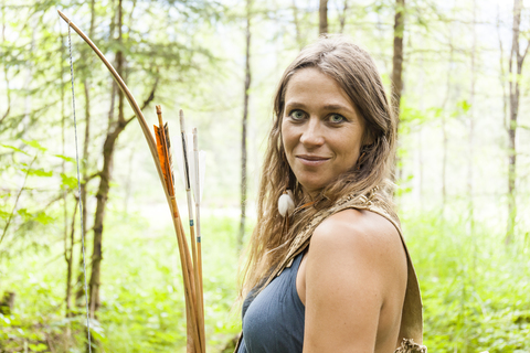 Portrait of smiling archeress in a forest stock photo