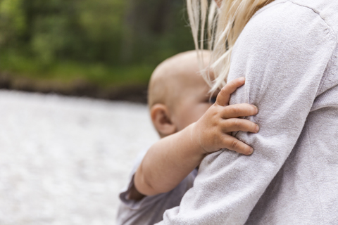 Girl holding baby boy brother in the nature stock photo