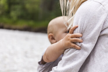 Mädchen hält kleinen Jungen Bruder in der Natur - TCF05798