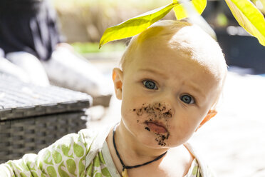 Portrait of baby boy with smeared face outdoors - TCF05803