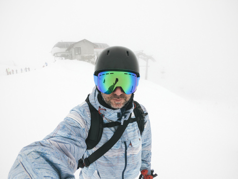 Italien, Modena, Cimone, Porträt eines Mannes mit Skibrille und Helm im Dunst, lizenzfreies Stockfoto