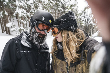 Selfie eines Paares in Skikleidung im Winterwald - JPIF00022
