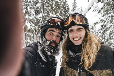 Selfie des glücklichen Paares in Skikleidung im Winterwald - JPIF00026