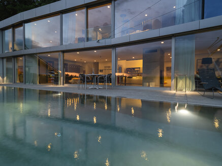 Schweiz, beleuchtete moderne Villa in der Abenddämmerung mit Pool im Vordergrund - LAF02078