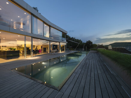 Schweiz, beleuchtete moderne Villa in der Abenddämmerung mit Terrasse und Pool im Vordergrund - LAF02080