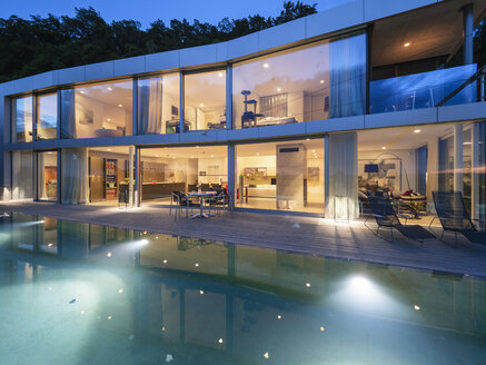 Schweiz, beleuchtete moderne Villa in der Abenddämmerung mit Pool im Vordergrund - LAF02084