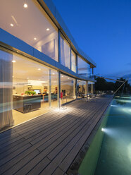 Schweiz, beleuchtete moderne Villa in der Abenddämmerung mit Terrasse und Pool im Vordergrund - LAF02085