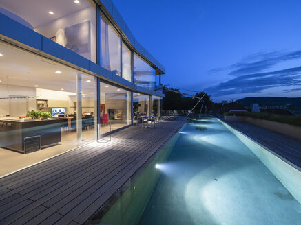 Schweiz, beleuchtete moderne Villa in der Abenddämmerung mit Terrasse und Pool im Vordergrund - LAF02086