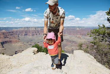USA, Arizona, Grand Canyon National Park, father and baby girl on viewpoint, girl learning to walk - GEMF02360