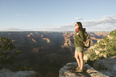 USA, Arizona, Grand Canyon National Park, Junge Frau mit Rucksack erkundet und genießt die Landschaft bei Sonnenuntergang - GEMF02361