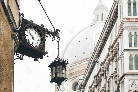 Italien, Florenz, alte Uhr und Laterne an Hausfassade im Winter, lizenzfreies Stockfoto