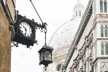 Italien, Florenz, alte Uhr und Laterne an Hausfassade im Winter - MGIF00206